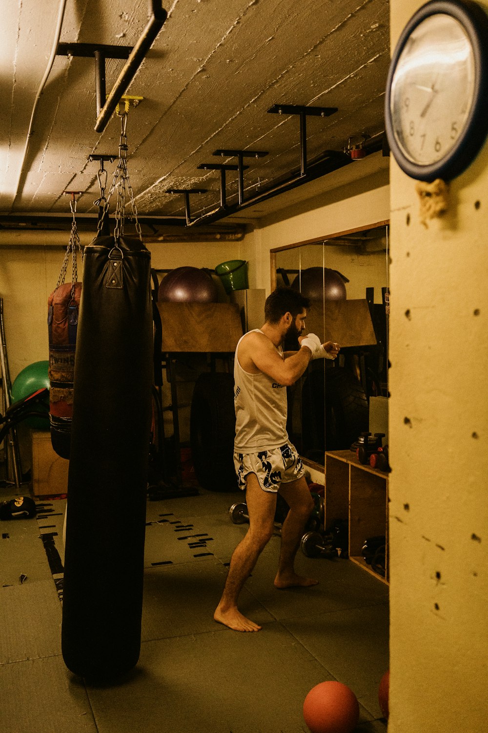 man in black shorts holding black and red boxing gloves