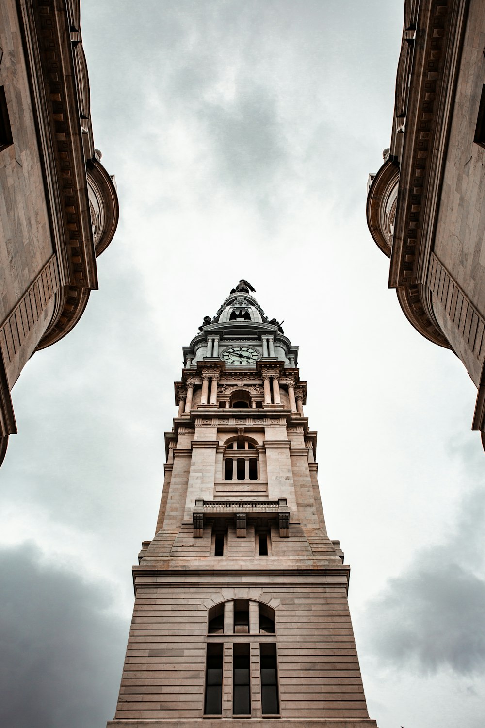 low angle photography of brown concrete building under white clouds during daytime