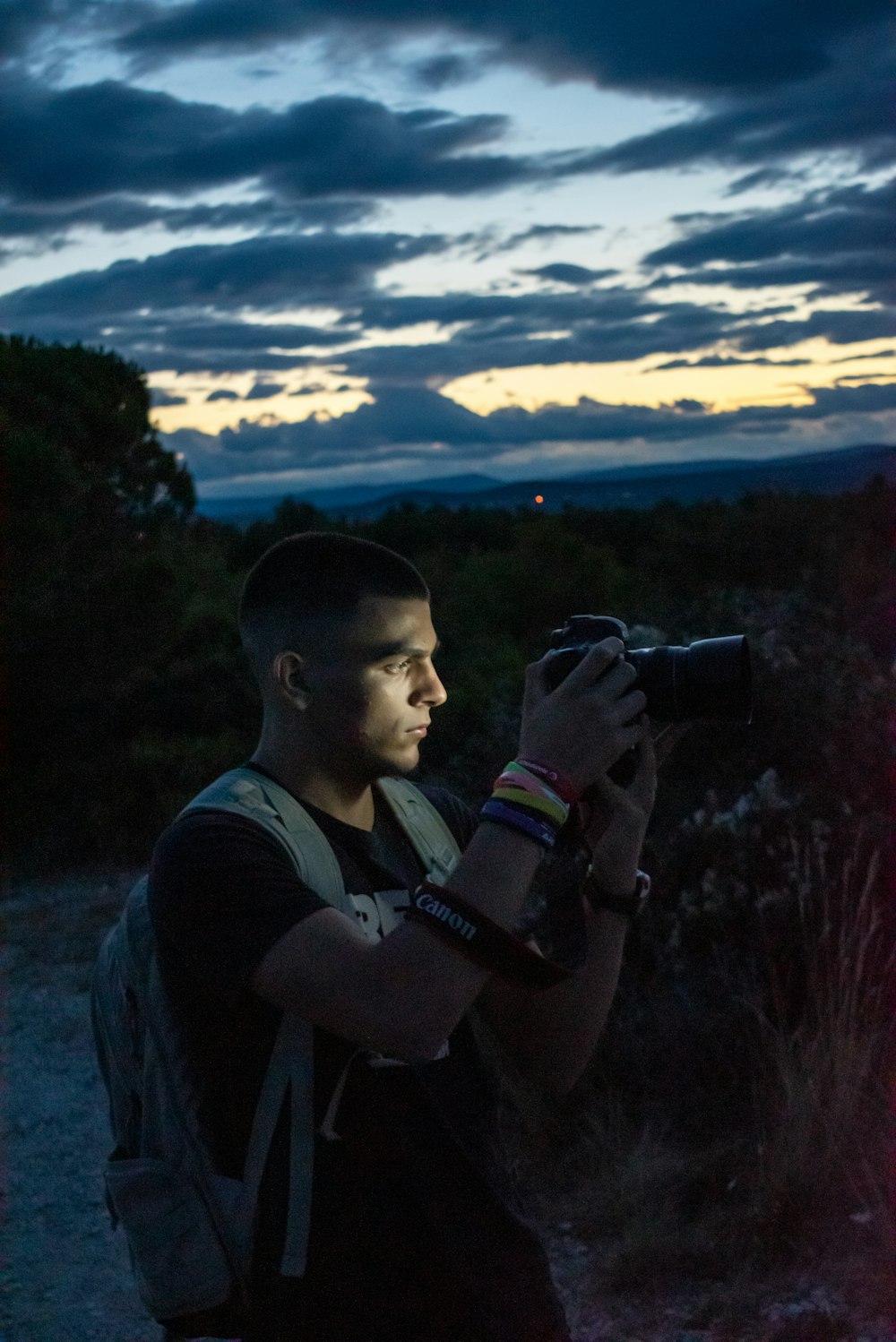 man in black and gray hoodie holding black dslr camera