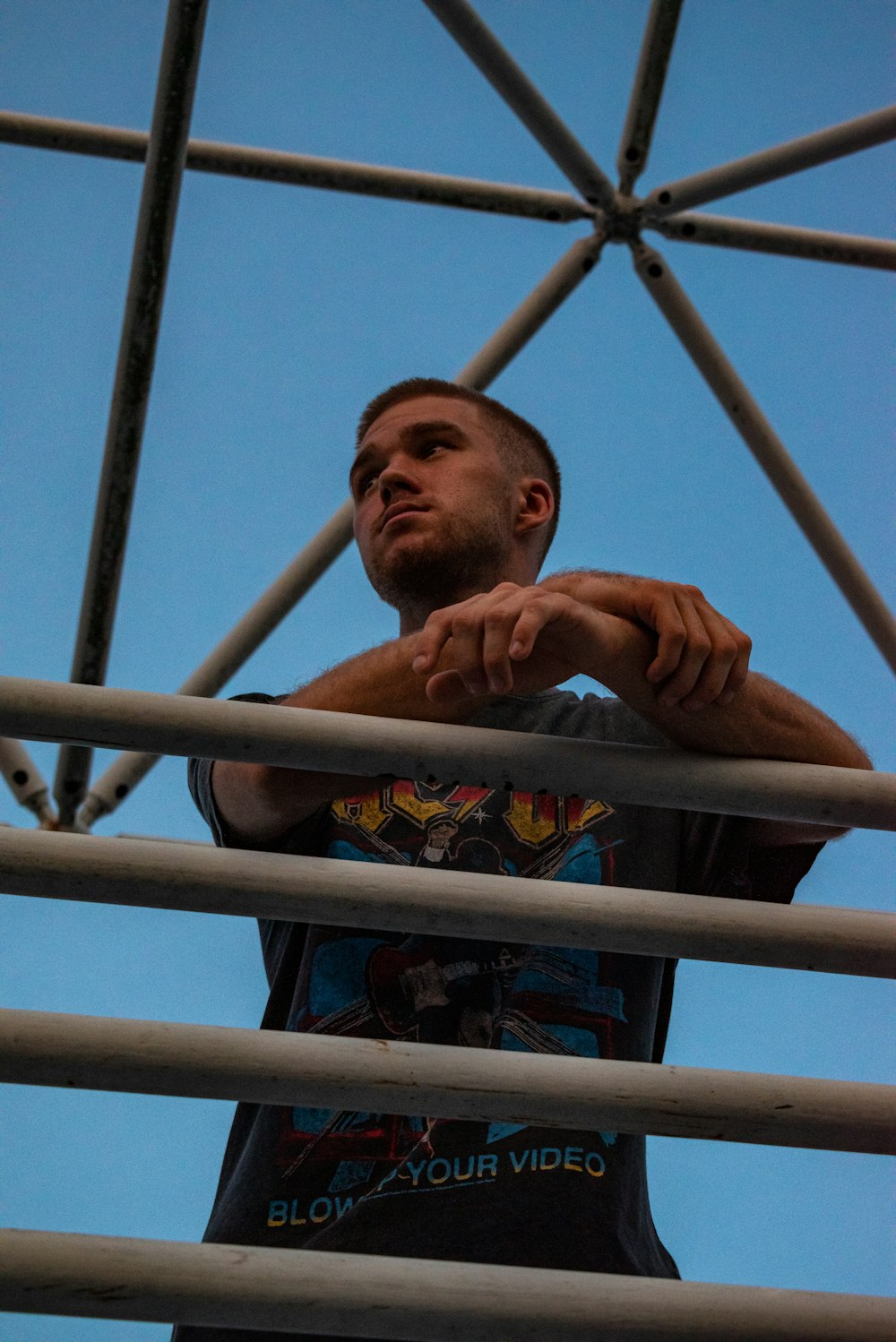 man in blue shirt standing on ladder during daytime