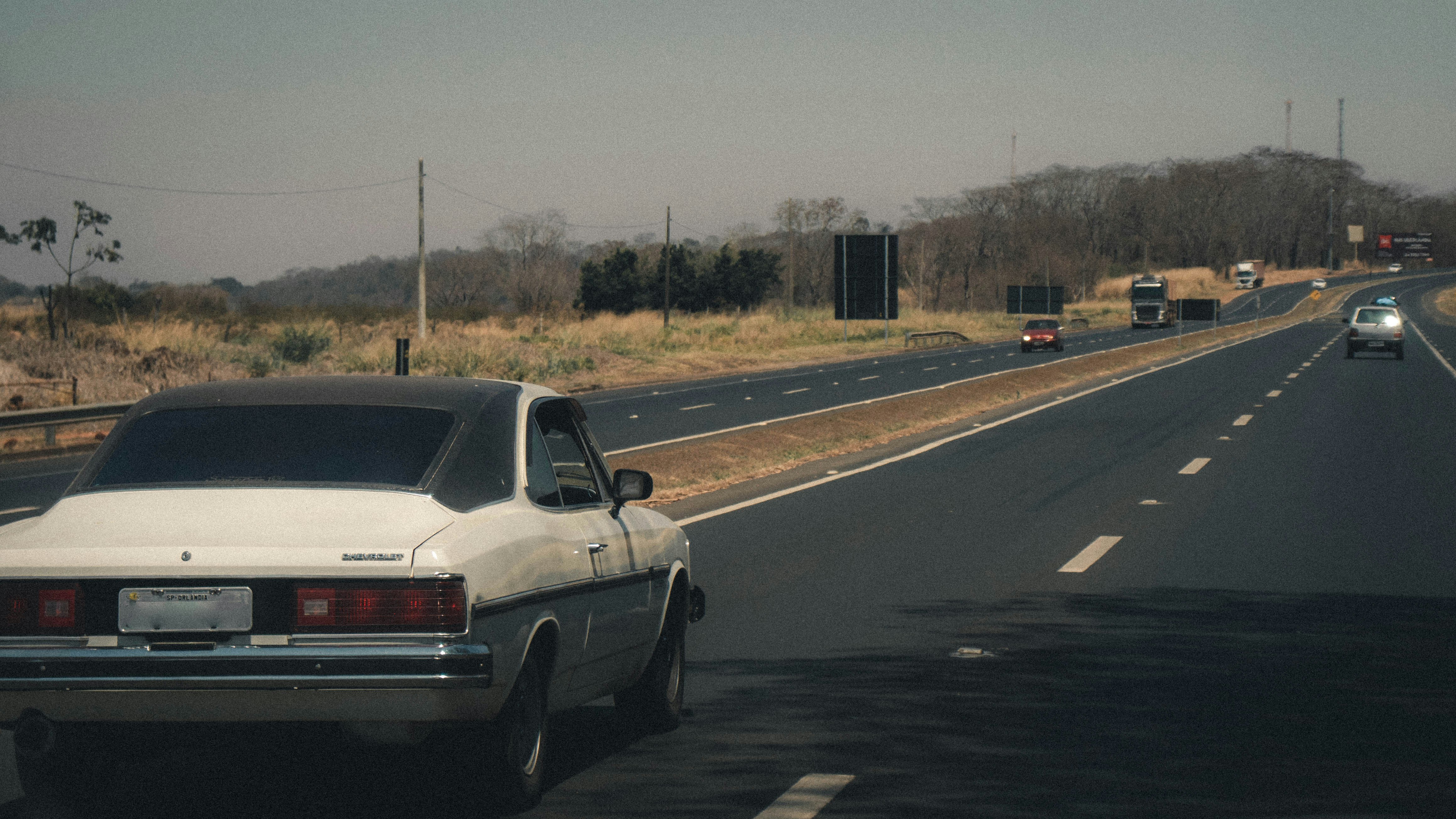 white sedan on road during daytime