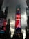 Tall skyscrapers under a cloudy sky surround a vibrant digital billboard displaying various advertisements in a bustling urban setting.