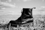 black leather boots on white metal rack
