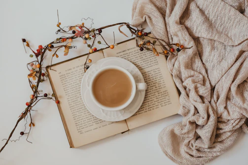 white ceramic mug on white book