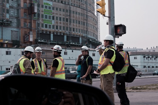 people in yellow and black jacket standing on road during daytime