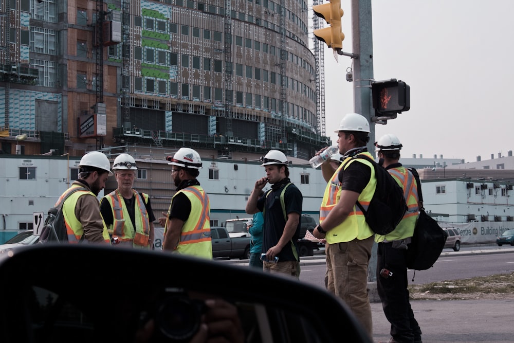 people in yellow and black jacket standing on road during daytime