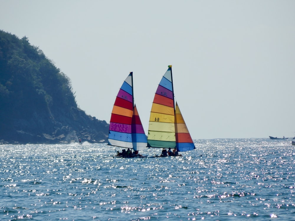yellow red and blue sail boat on sea during daytime