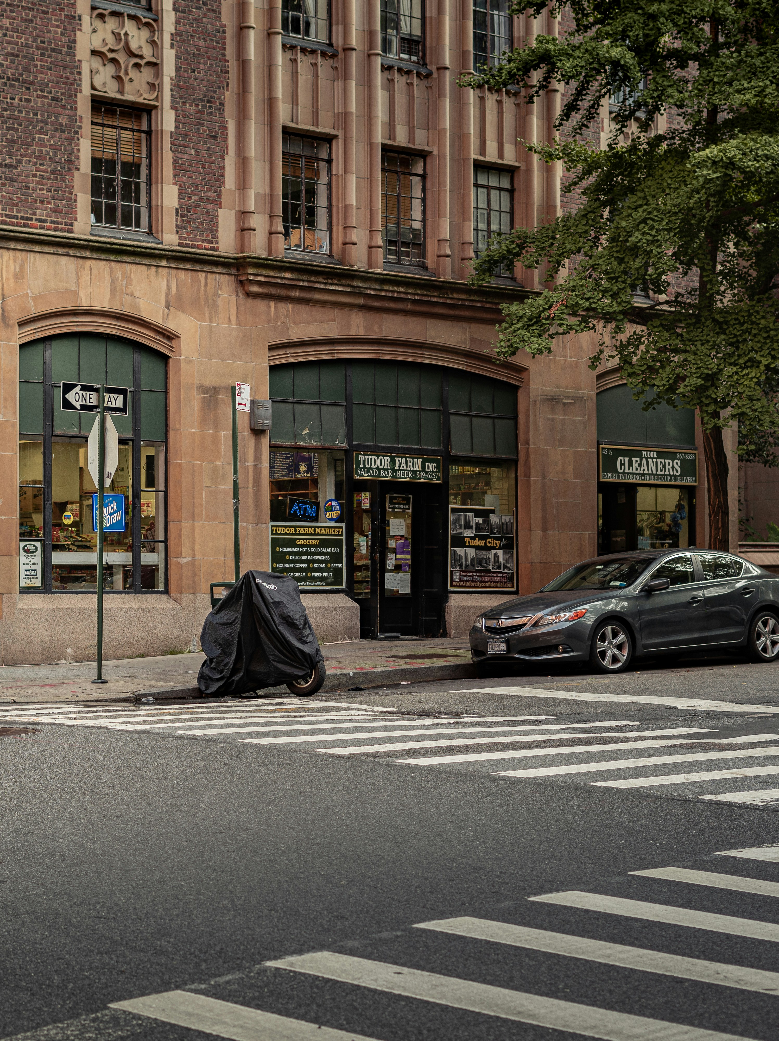 black sedan parked beside brown building during daytime