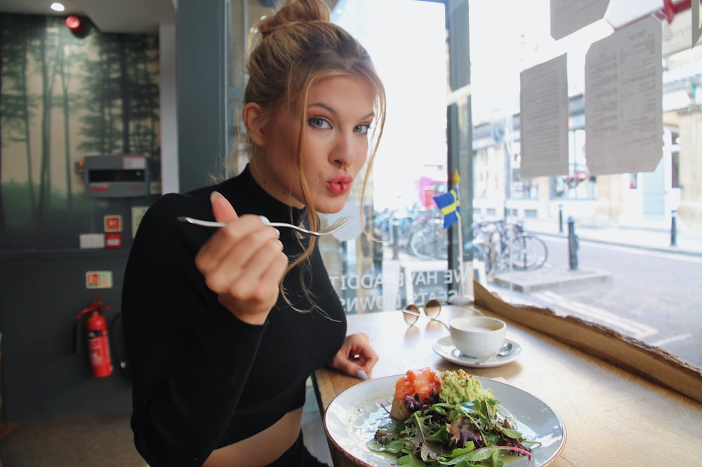 woman in black long sleeve shirt eating