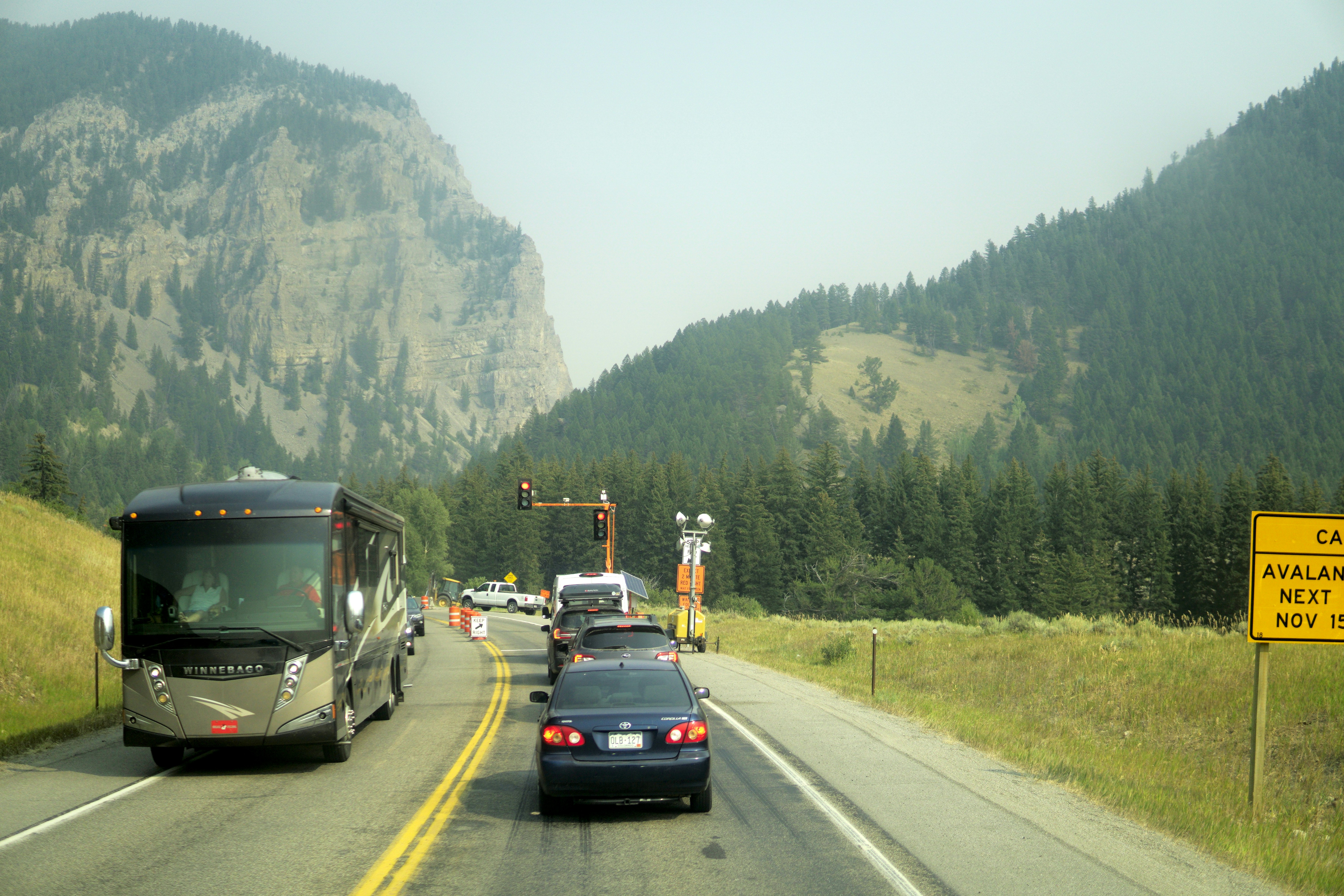 Family driving a modern electric SUV on a scenic highway, suggesting long-distance EV range