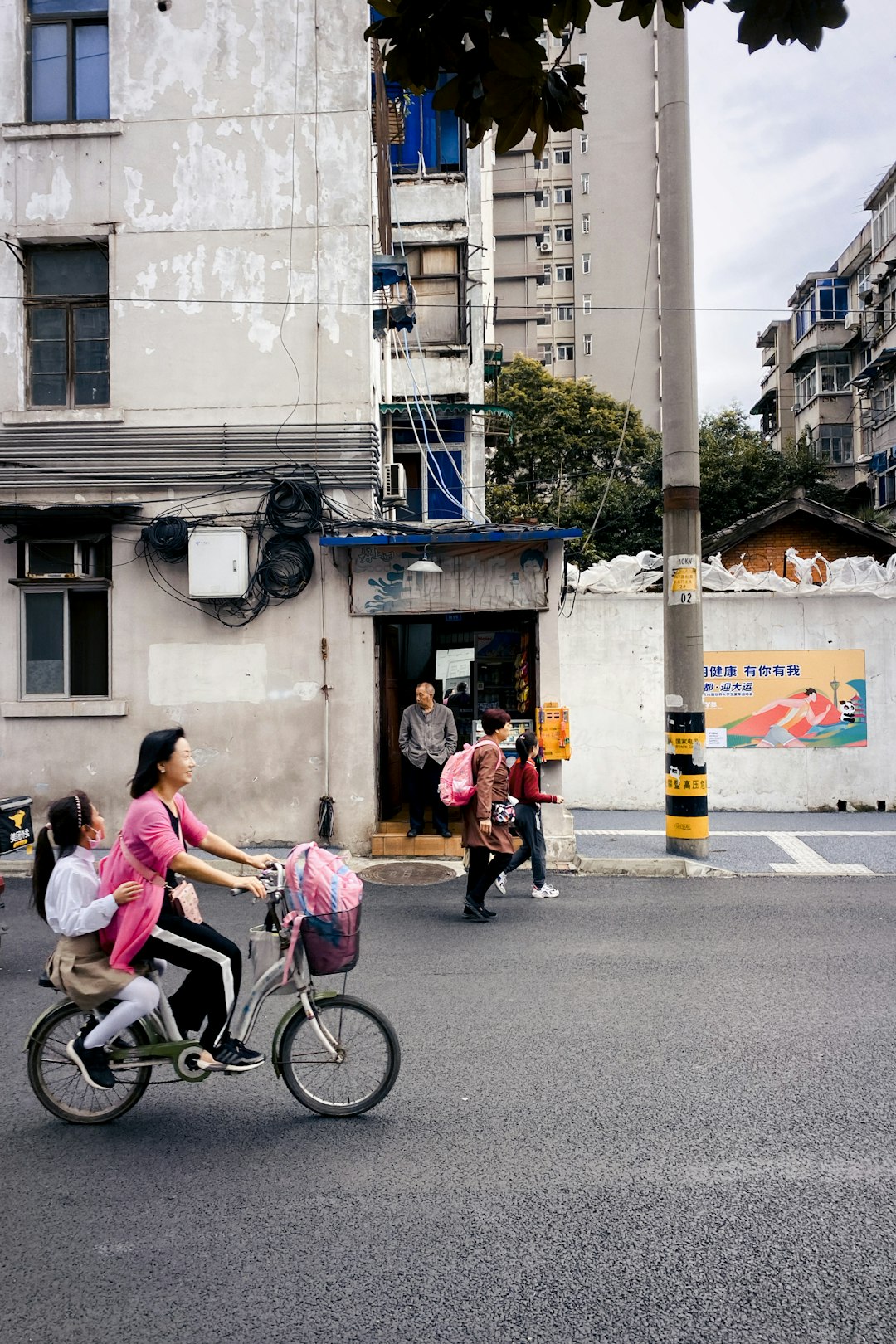 woman in pink jacket riding bicycle on road during daytime