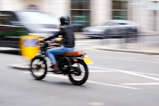 A rider wearing a helmet cruising through Medellín's urban landscape on a Yamaha motorcycle.