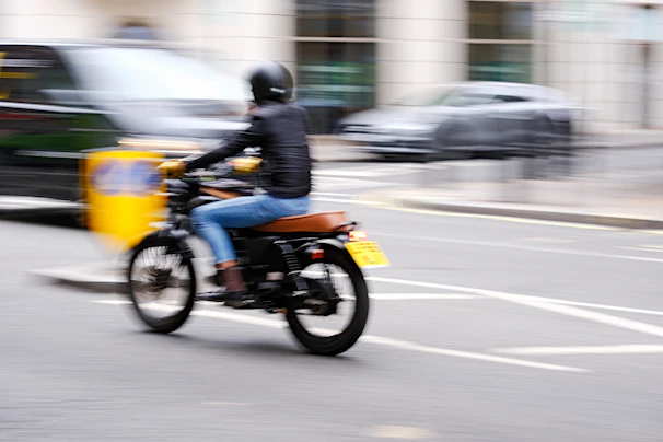 A rider wearing a helmet cruising through Medellín's urban landscape on a Yamaha motorcycle.