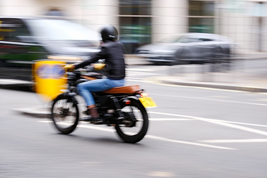 man in black jacket riding yellow motorcycle on road during daytime