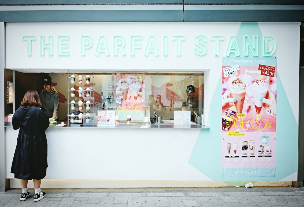 a woman standing in front of a store window