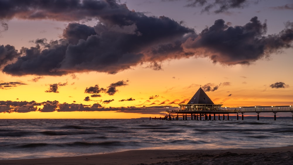 silhouette of beach dock during sunset