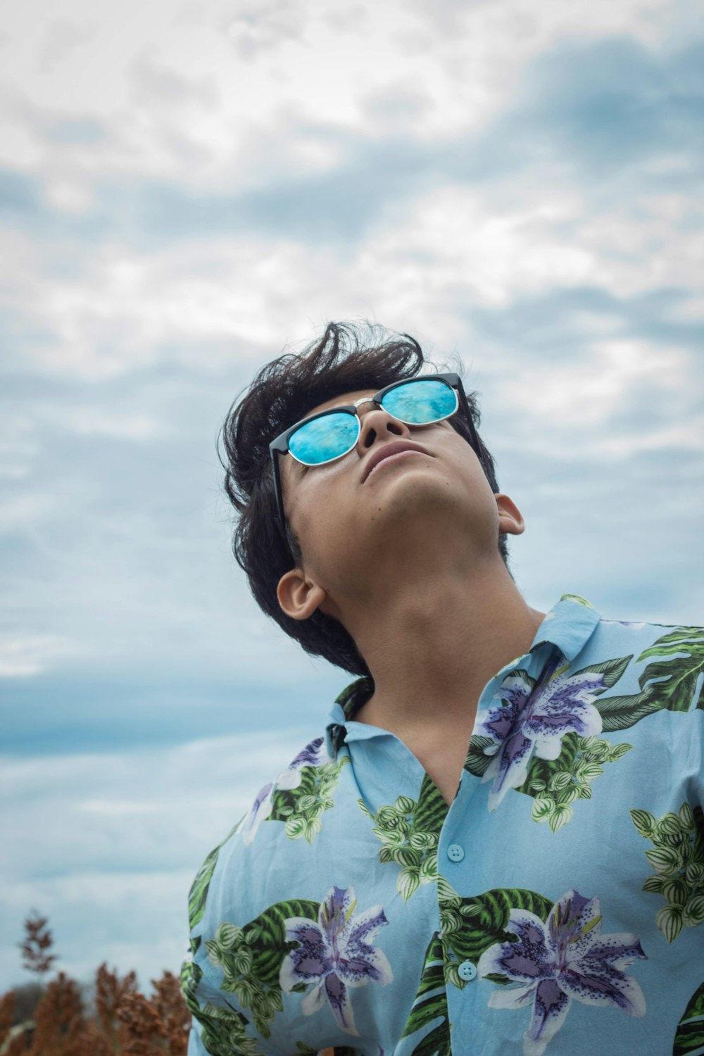 woman in green floral shirt wearing blue sunglasses under blue sky during daytime