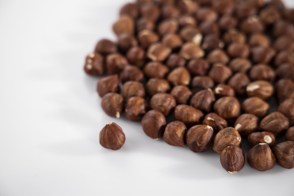 braune Kaffeebohnen auf weißer Oberfläche