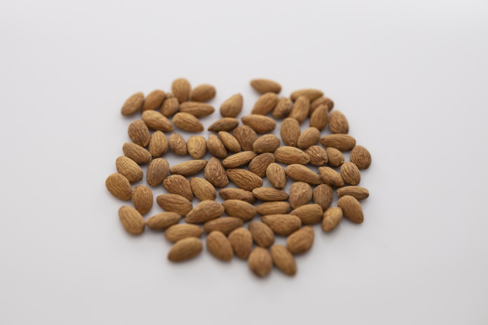 brown almond nuts on white surface