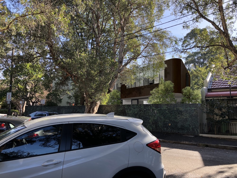 white car parked near brown house