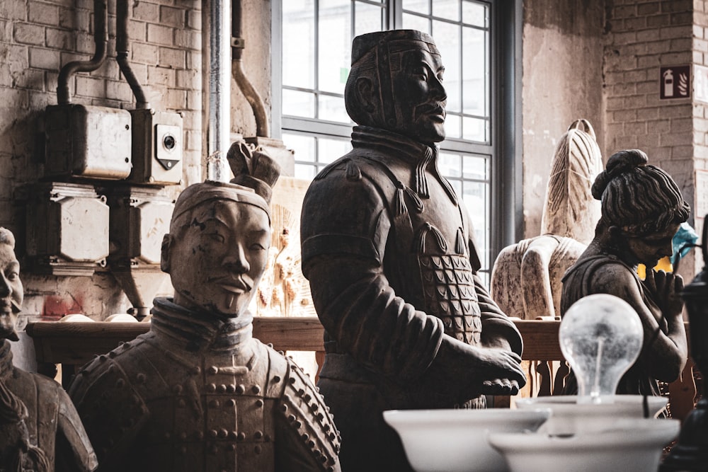 man in black jacket sitting beside man in black jacket statue