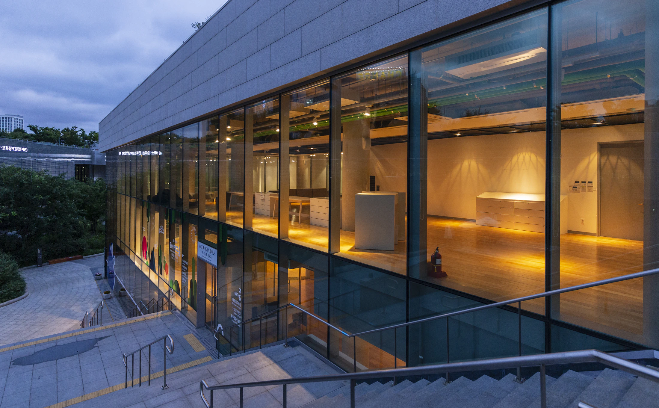 A modern building with warmly lit windows at dusk
