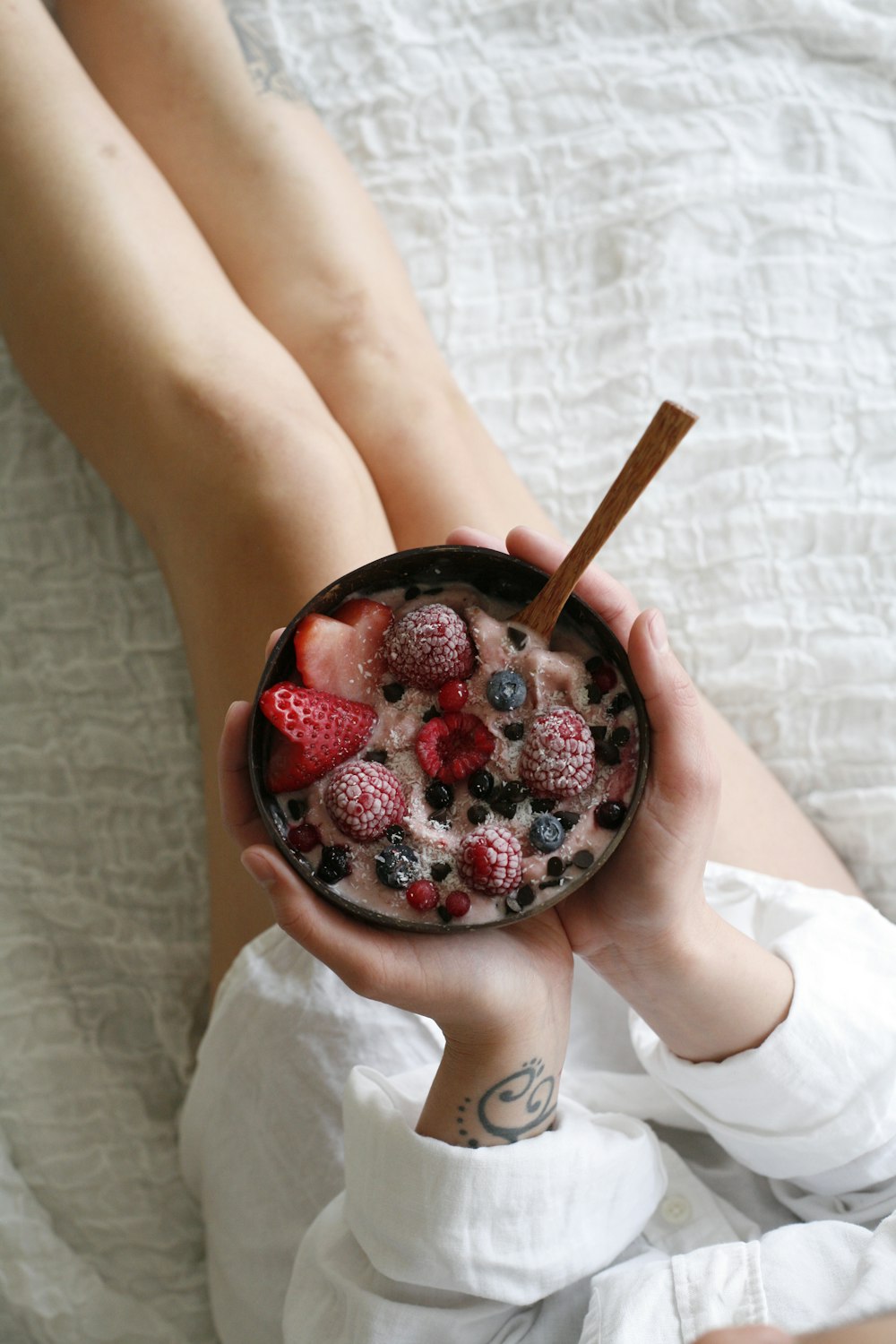 person holding bowl of strawberries