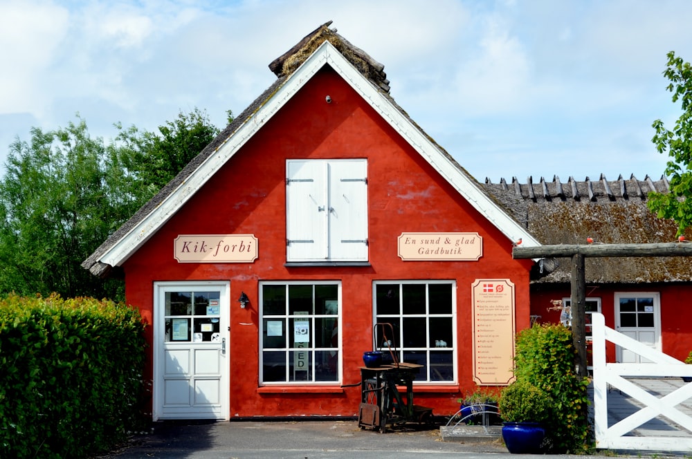 red and white wooden house near green trees during daytime