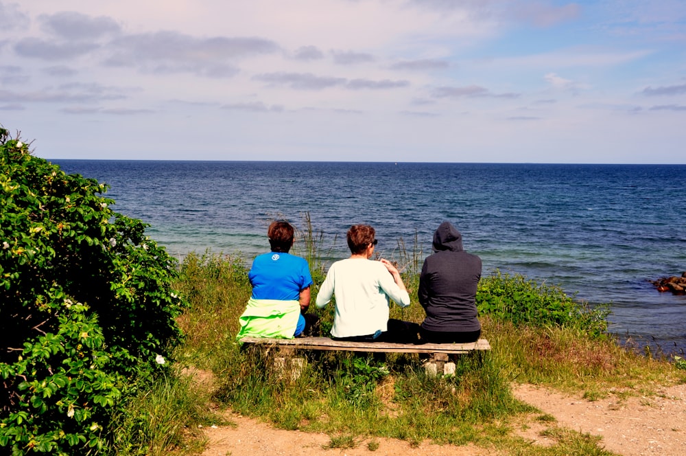 couple sitting on bench near body of water during daytime