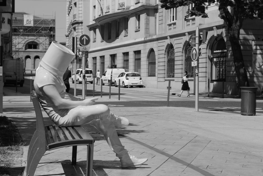 Photo en niveaux de gris d’une femme assise sur un banc