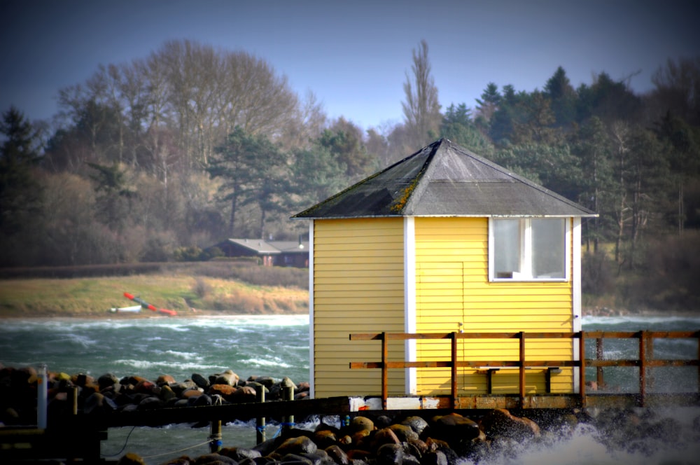 brown wooden house near body of water during daytime