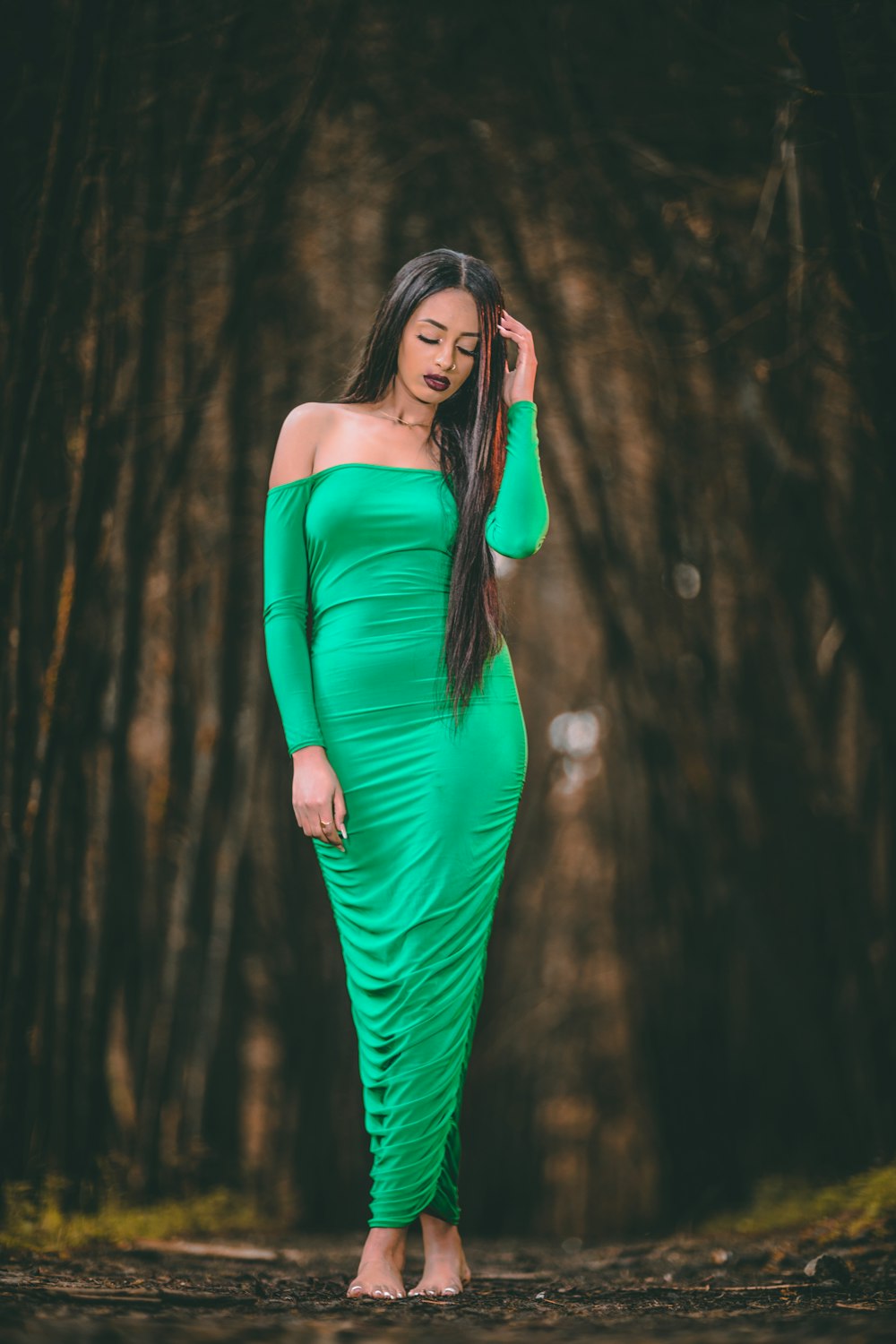 woman in green long sleeve dress standing in the woods