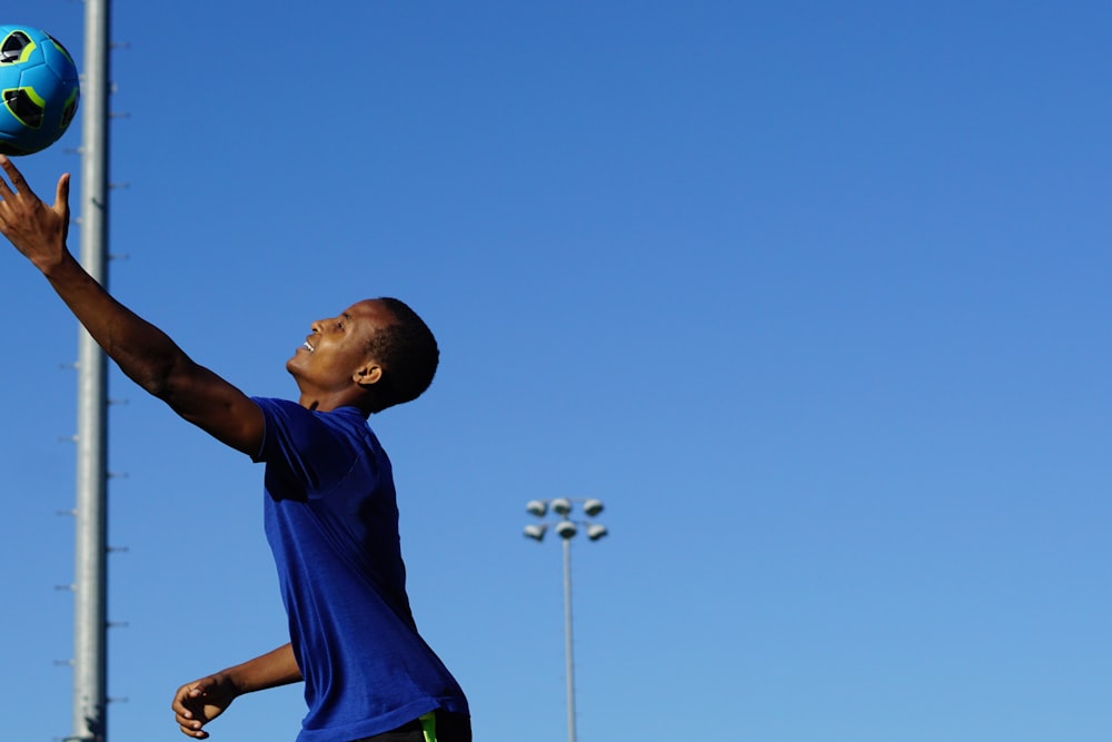 boy in blue shirt standing under blue sky during daytime