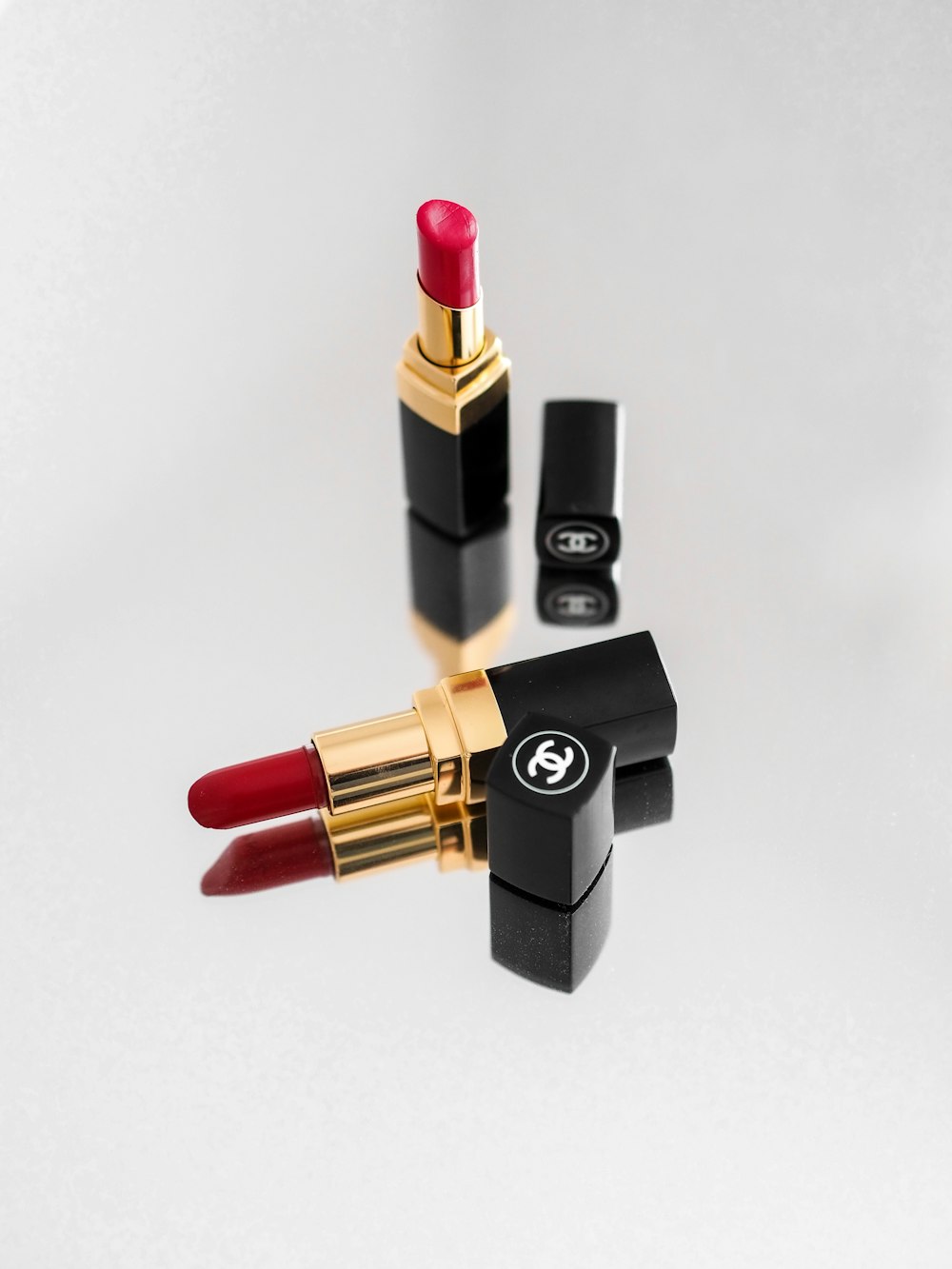 red lipstick beside black and gold lipstick