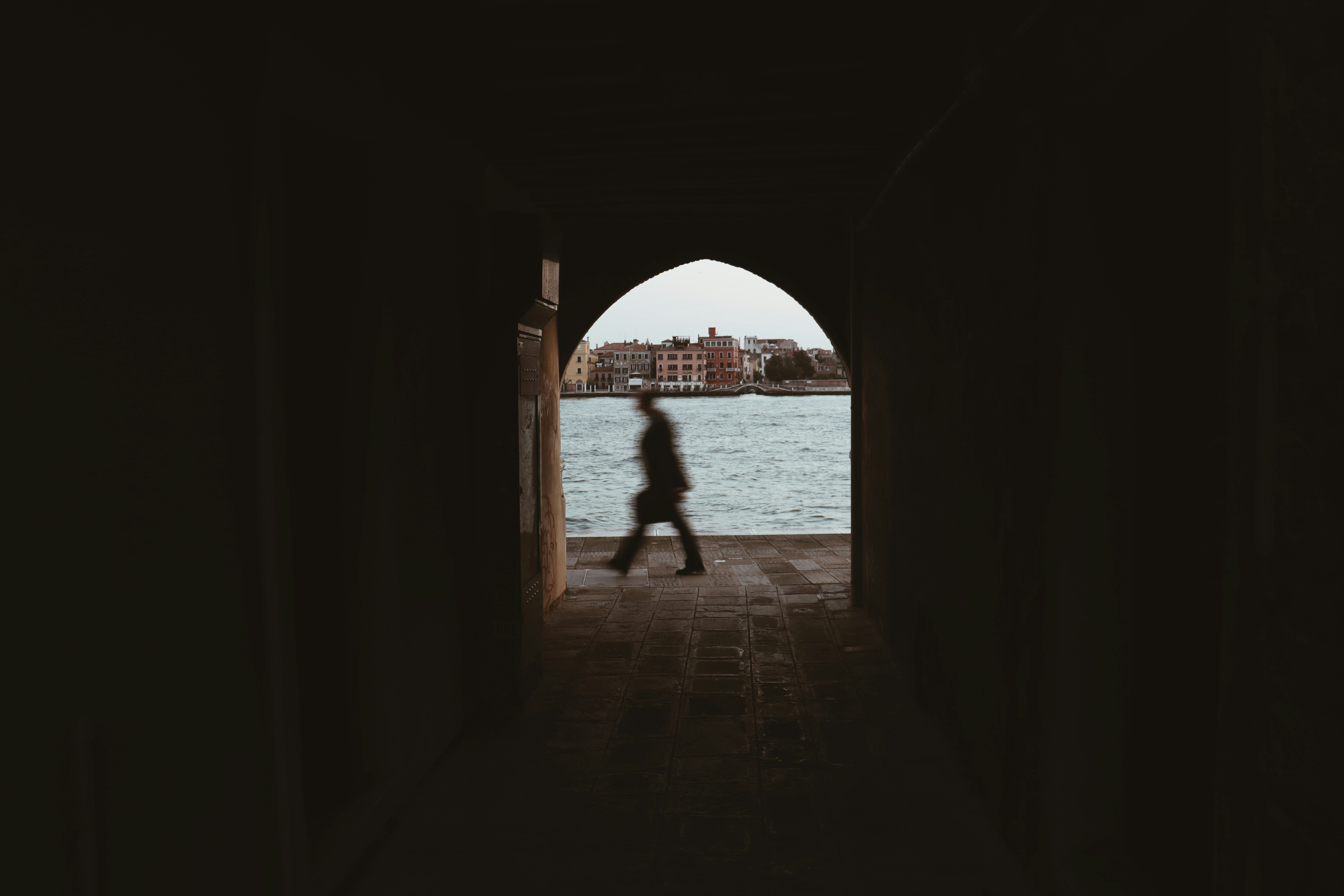 silhouette of person walking on hallway during daytime