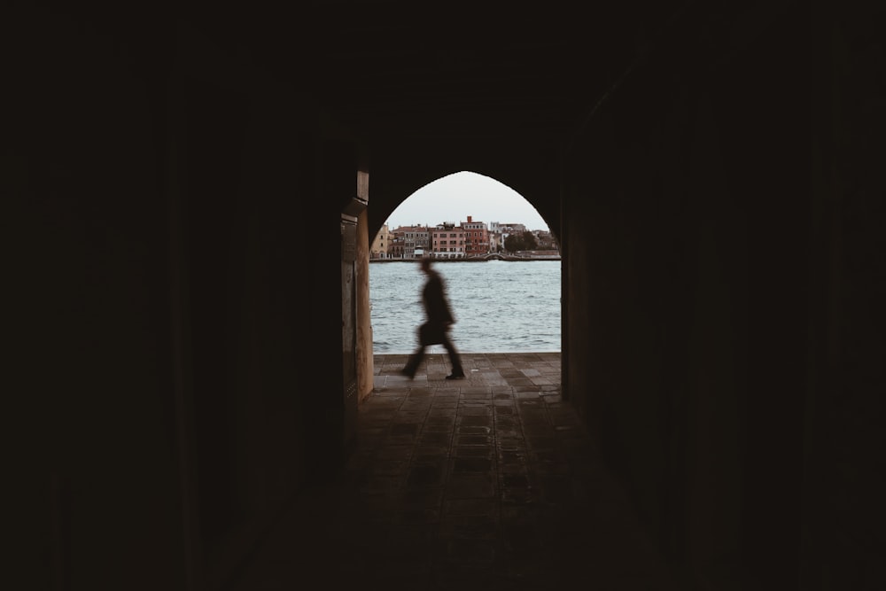 silhouette of person walking on hallway during daytime