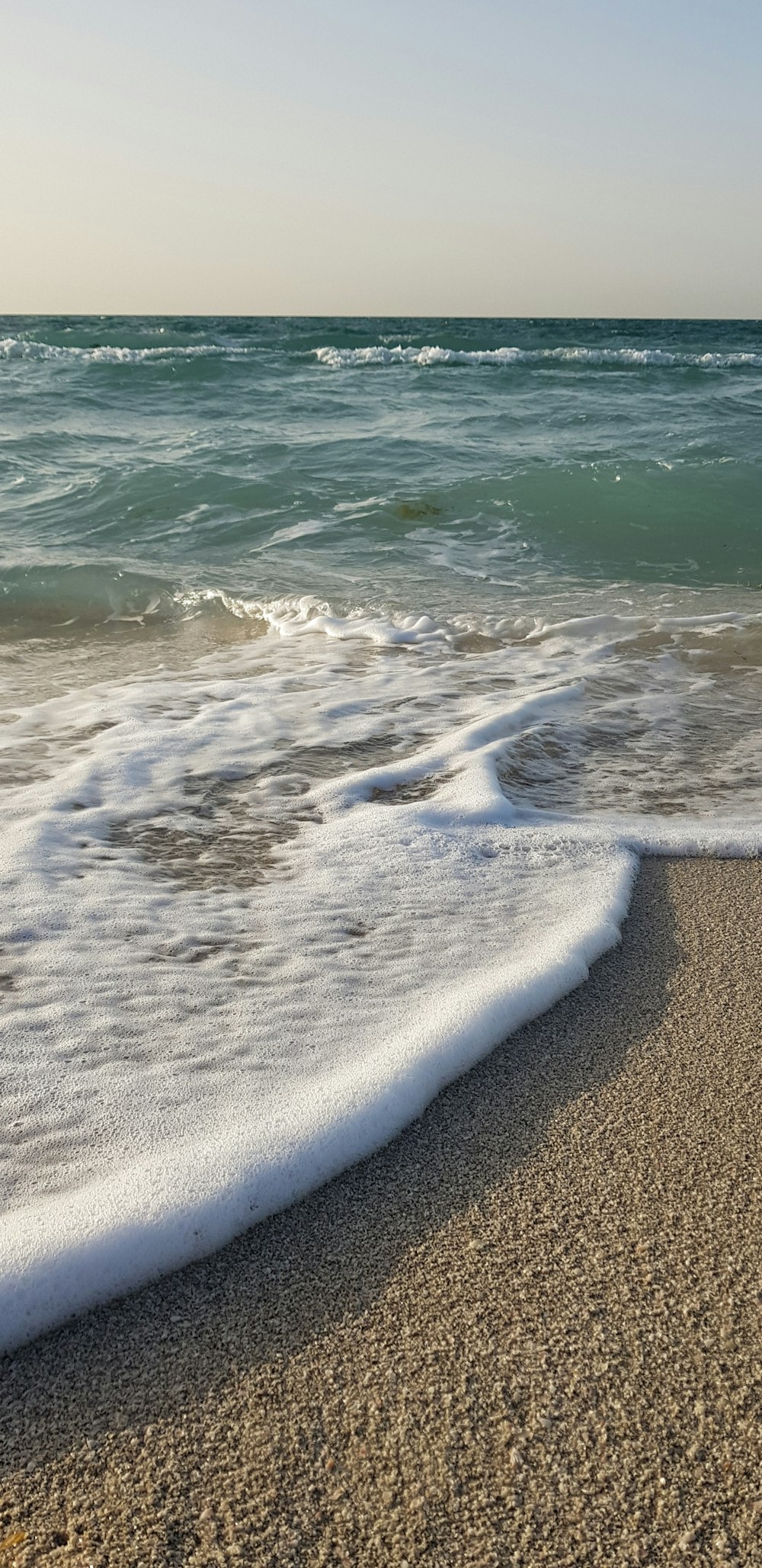 onde del mare che si infrangono sulla riva durante il giorno