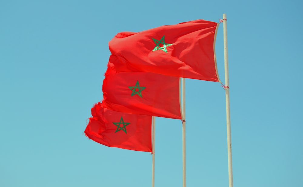 red flag on pole under blue sky during daytime