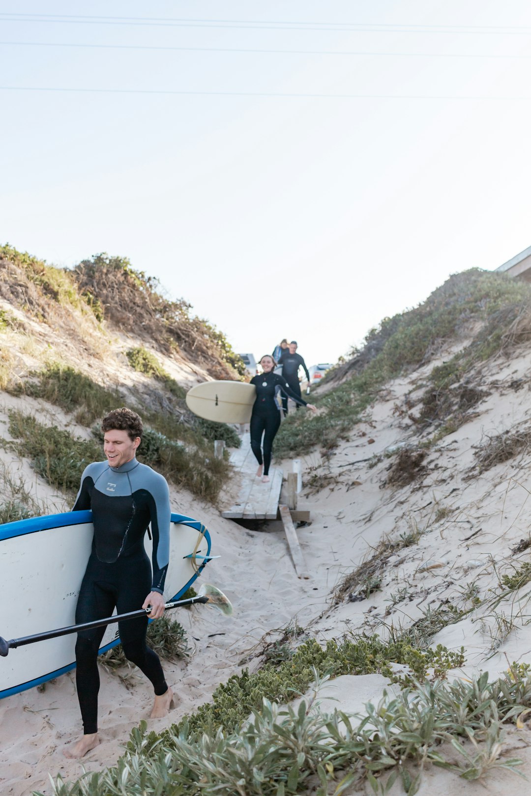 man in blue shirt holding white surfboard