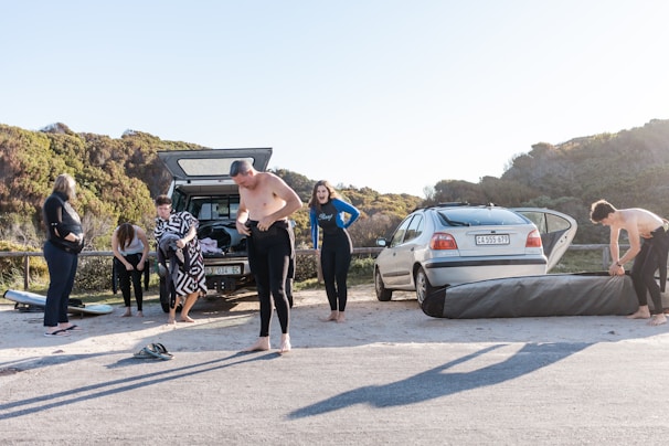 A community gathering by the beach promoting safe driving with aloha signs.