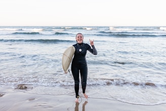 A smiling instructor guiding a beginner surfer on a gentle wave.