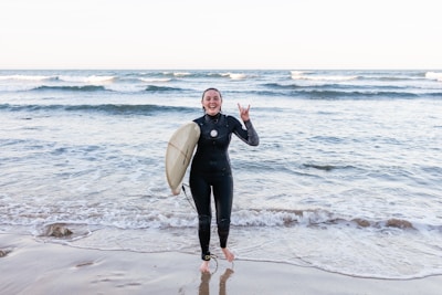A smiling instructor guiding a beginner surfer on a gentle wave.
