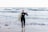 A smiling customer participating in a surfing lesson.