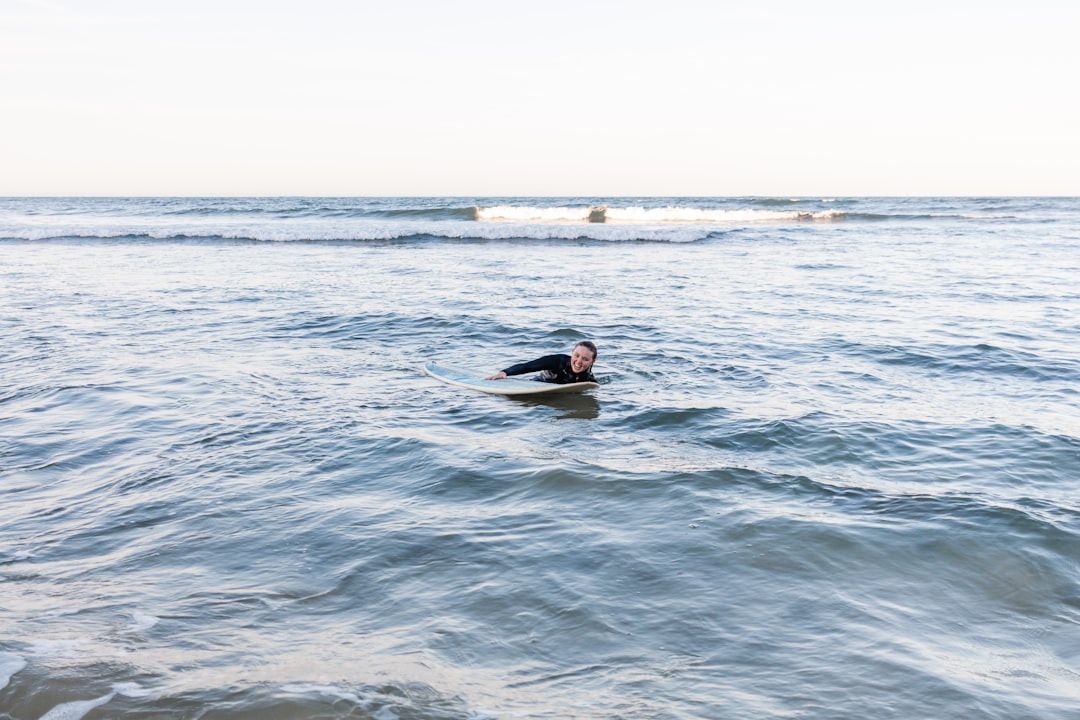 man in black wetsuit surfing on sea during daytime