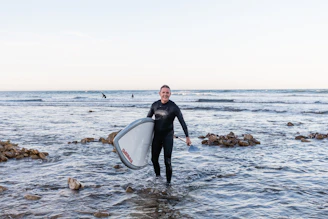 Instructor guiding a young surfer through paddling techniques in calm waters.