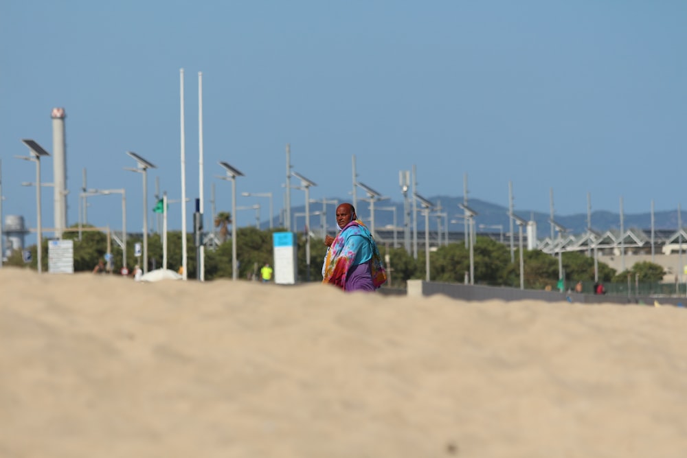 woman in red and blue dress sitting on brown sand during daytime