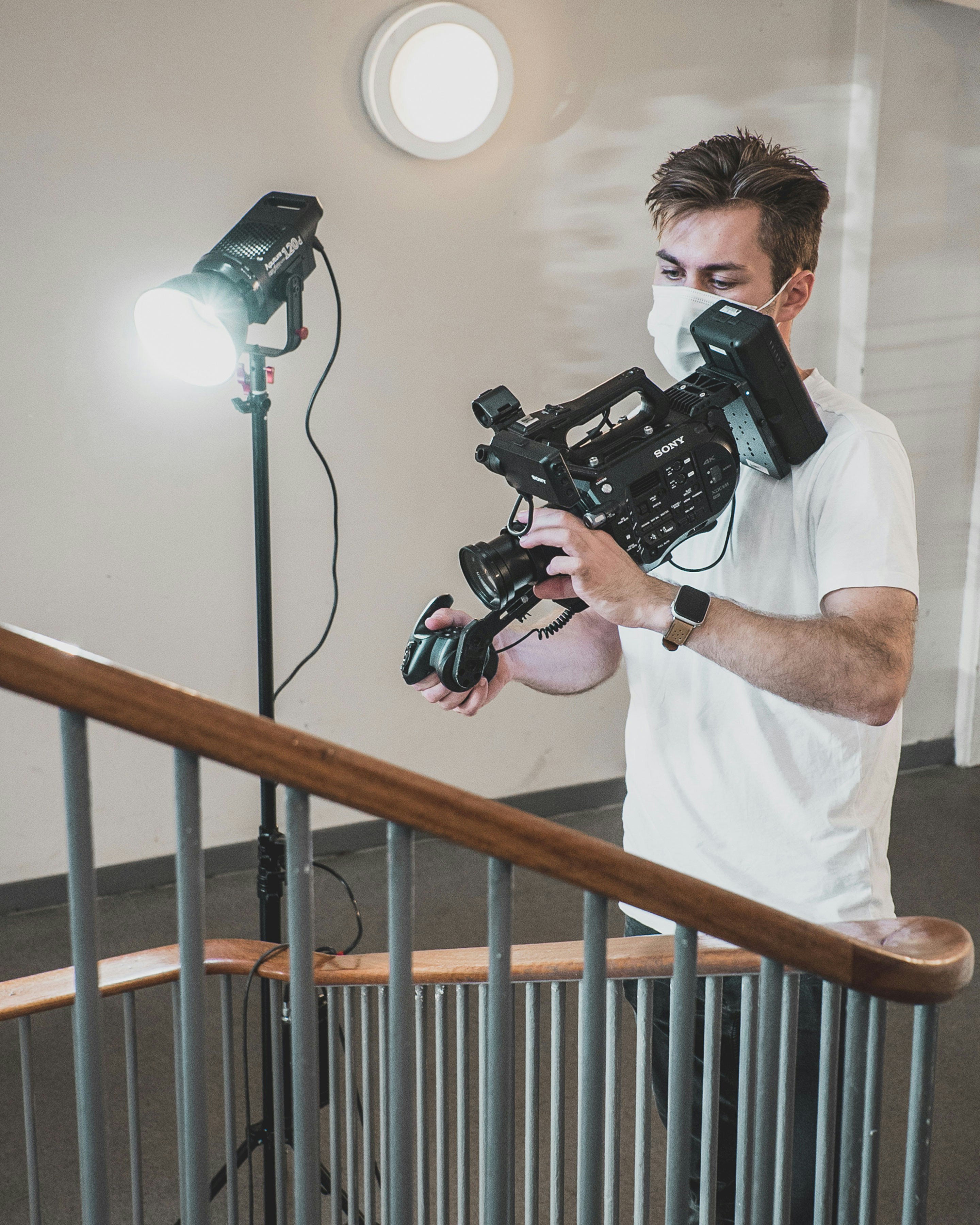 Camera operator filming with a cinema camera on a gimbal indoors