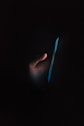 person holding blue light in dark room