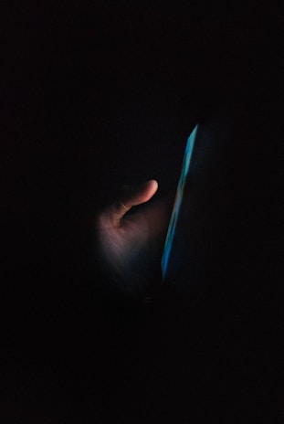 A late-night coaching call happening on a smartphone illuminated by soft light.