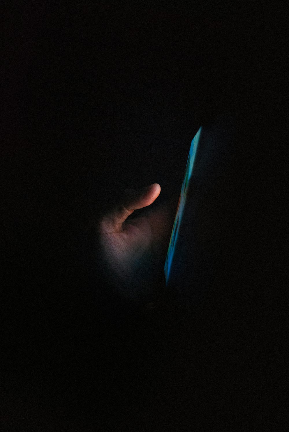 person holding blue light in dark room